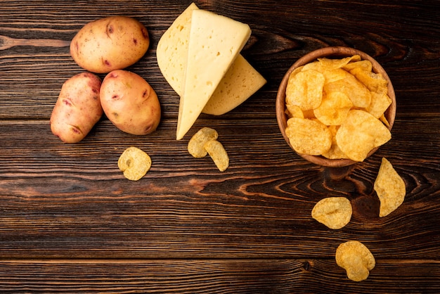 Batatas fritas com queijo na mesa de madeira