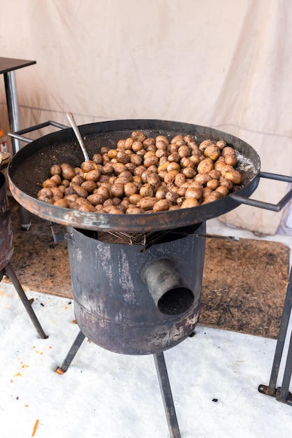 Batatas fritas cozidas em panela wok de metal grande no mercado de rua