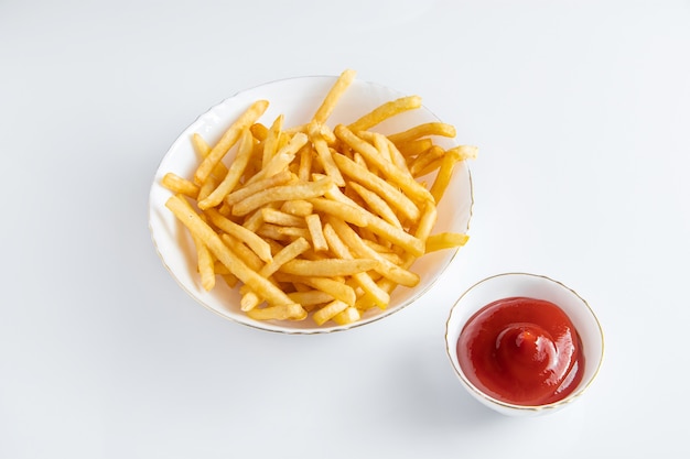 Batatas fritas crocantes em um prato em um fundo branco. Fast food americano quente.