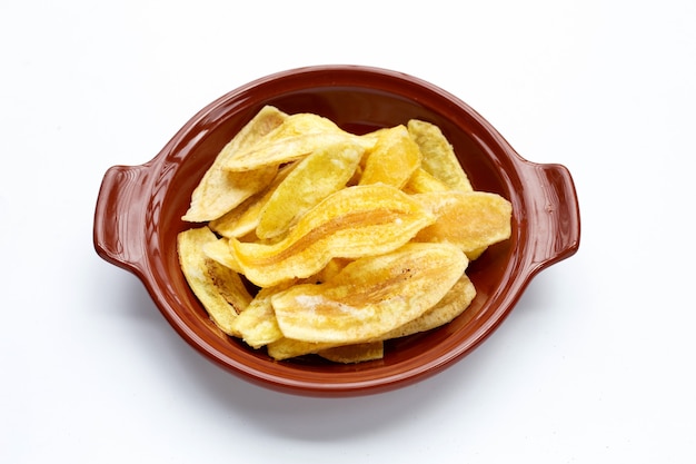 Batatas fritas de banana em uma tigela no fundo branco