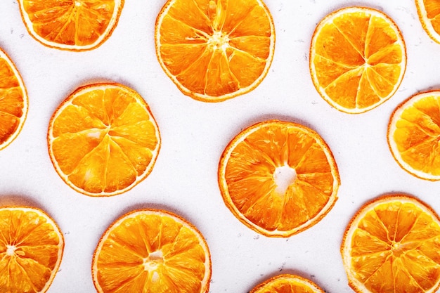 Foto batatas fritas de frutas secas em fatias de laranja em fundo de pedra branca