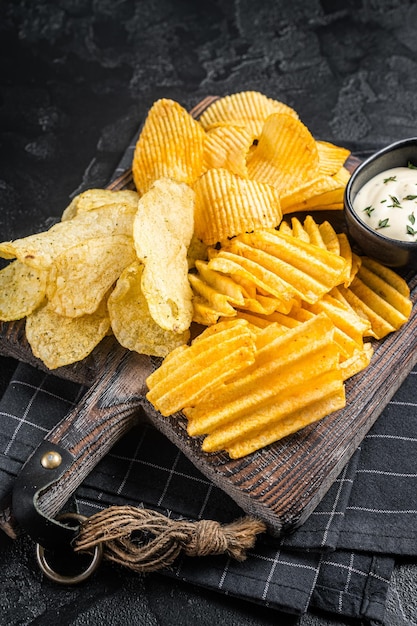 Batatas fritas deliciosas Enrugar churrasco quente caseiro em uma placa de madeira Fundo preto Vista superior