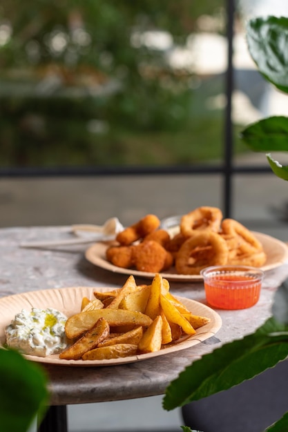 Batatas fritas e anéis de cebola em um prato fast food street food