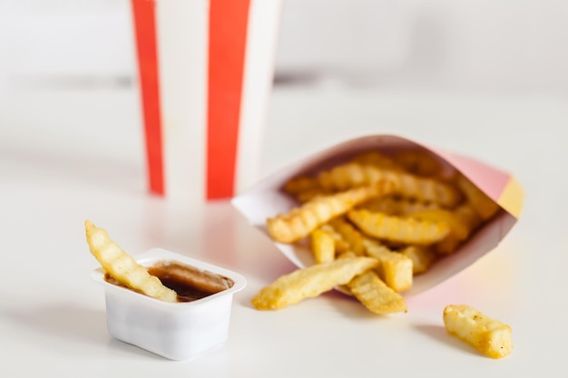 Foto batatas fritas e coca-cola em um fundo branco, foco seletivo.