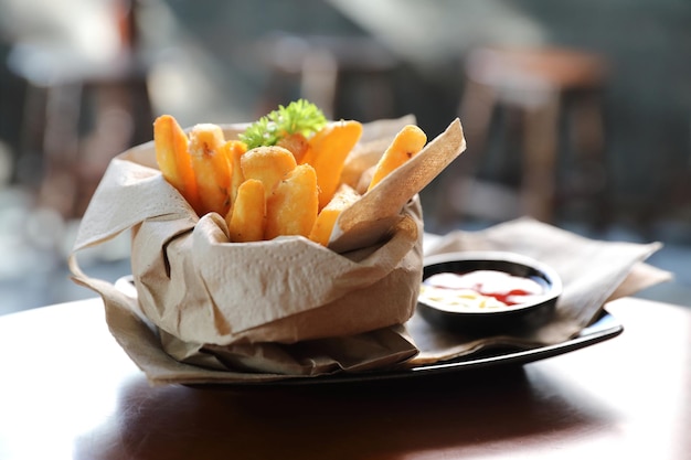 Batatas fritas em estilo vintage em fundo de madeira