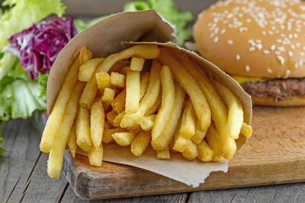 Batatas fritas em papel com hambúrguer