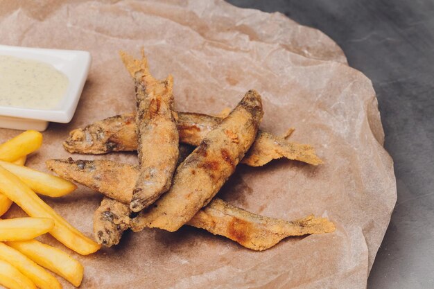 Batatas fritas em um prato na mesa de madeira