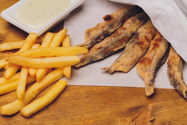 Batatas fritas em um prato na mesa de madeira