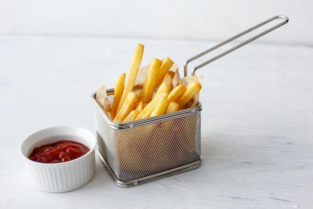 Batatas fritas em uma cesta de fast food em um fundo branco