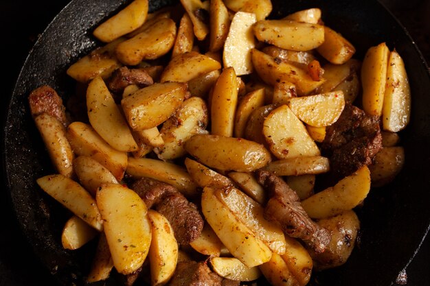 Batatas fritas em uma panela com carne Processo de cozimento