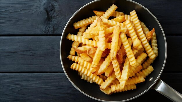 Foto batatas fritas em uma panela com fundo de madeira preta