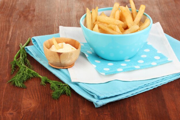 Batatas fritas em uma tigela na mesa de madeira closeup