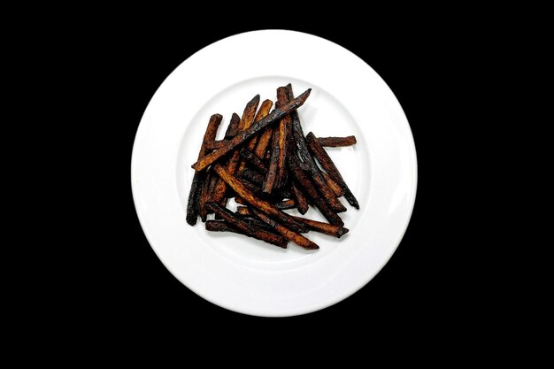 Foto batatas fritas enegrecidas em um prato branco carbonizado