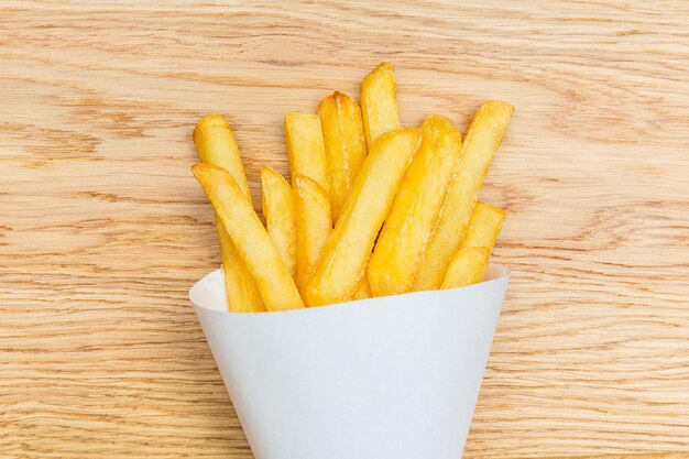 Batatas fritas Pommes em fundo de madeira