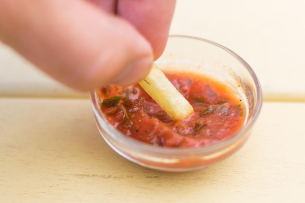 Batatas fritas são mergulhadas em ketchup