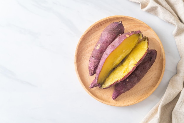 Batatas japonesas a la parrilla o al horno en un plato de madera