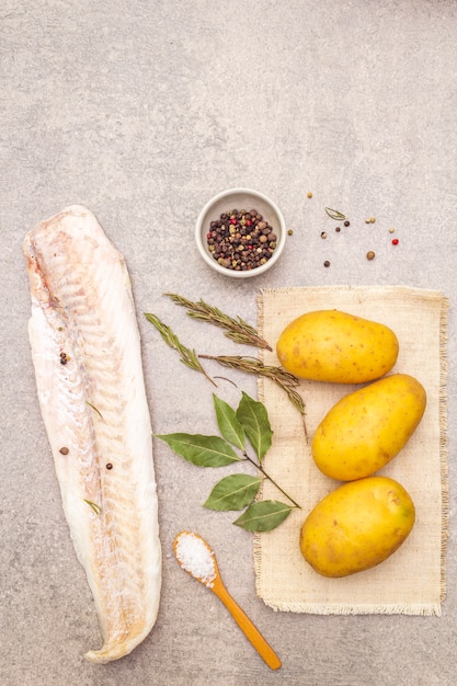 Batatas jovens cruas e filetes de pescada congelados com ervas e especiarias