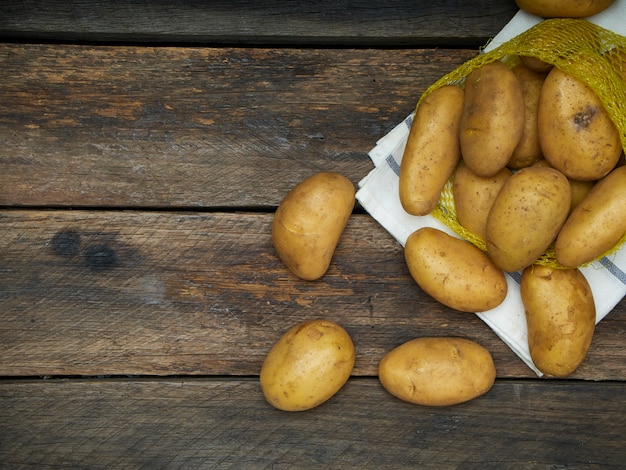 Batatas na mesa de madeira velha.