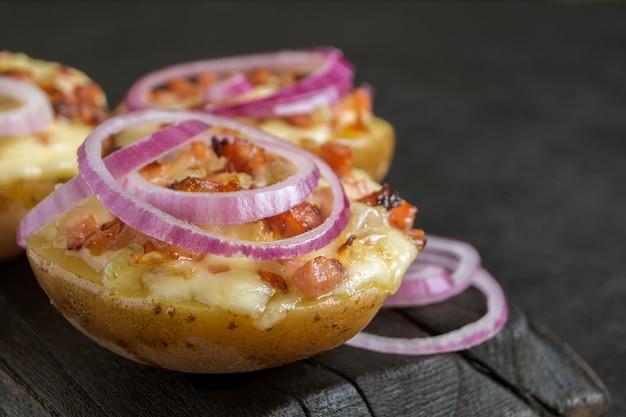 Foto batatas recheadas quentes assadas com queijo, bacon e salsa