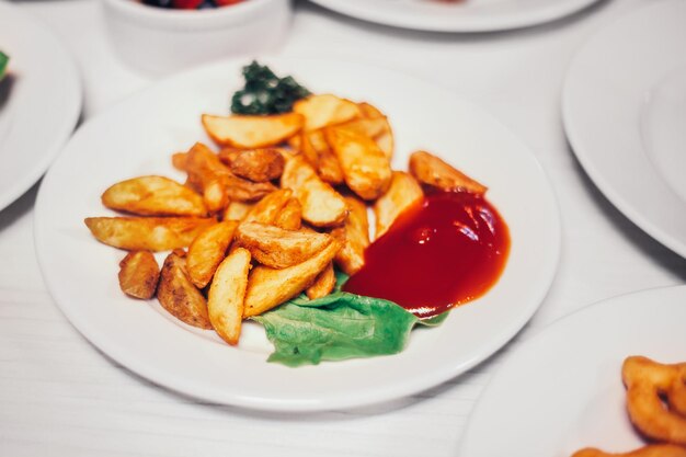 Batatas rústicas com molho e outros pratos na mesa