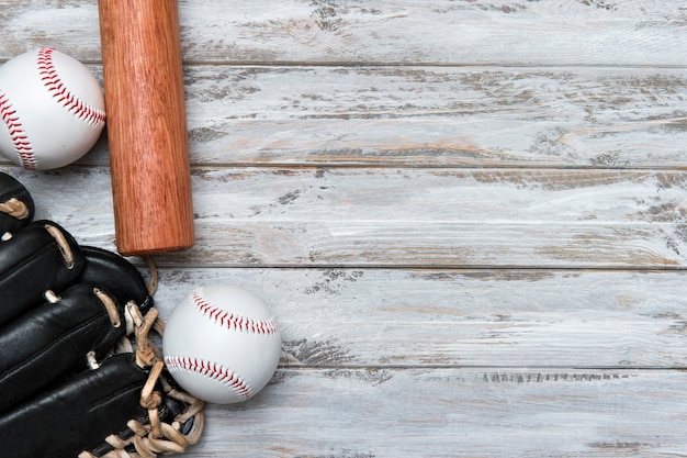 Foto bate de béisbol, guante y pelota sobre fondo de madera