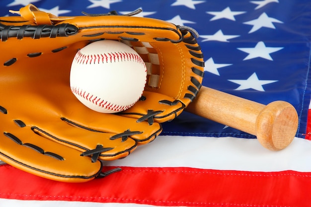 Foto bate y bola del guante de béisbol en fondo de la bandera americana