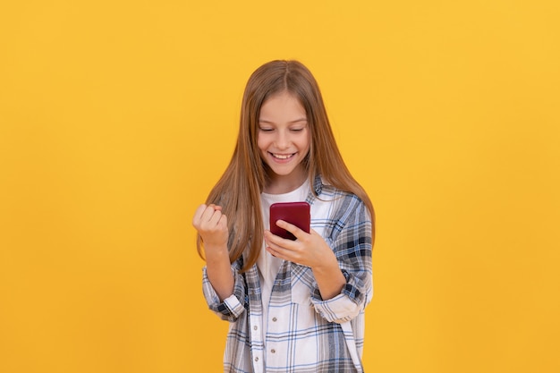 Bate-papo de menina adolescente feliz online. blogging escolar. tecnologia de comunicação moderna. criança blogueira usa smartphone. criança estuda online. digitar e enviar mensagens de texto. sms e mensagens instantâneas. infância.