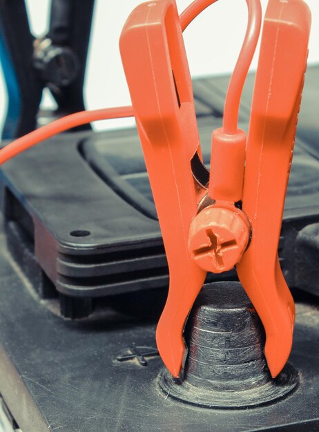 Batería de coche con abrazaderas y cables conectados de cargador