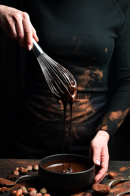 Bateria de metal de cozinha em chocolate Utensílios de cozinha sobre um fundo preto