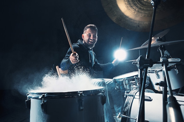 Baterista ensaiando bateria antes do show de rock. homem gravando música na bateria em estúdio com efeito show na forma de farinha