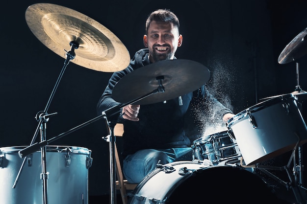 El baterista ensayando la batería antes del concierto de rock Hombre grabando música en la batería