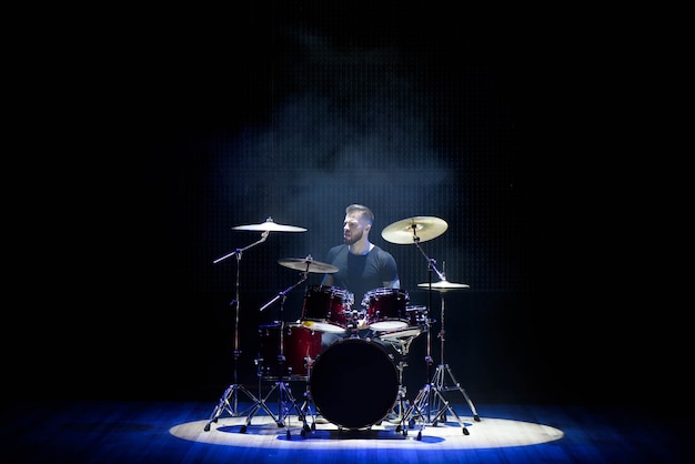 Baterista tocando bateria com fumaça e pó