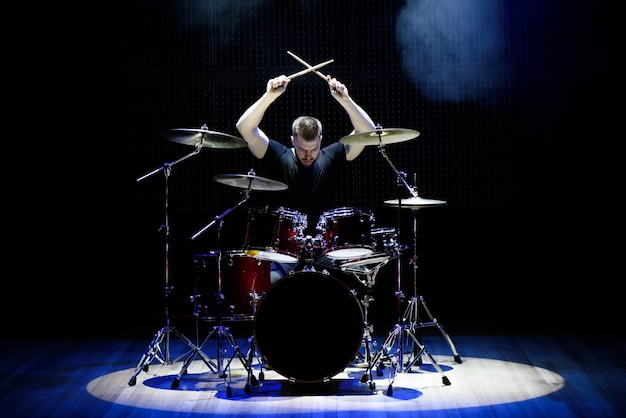 Foto baterista tocando bateria no palco