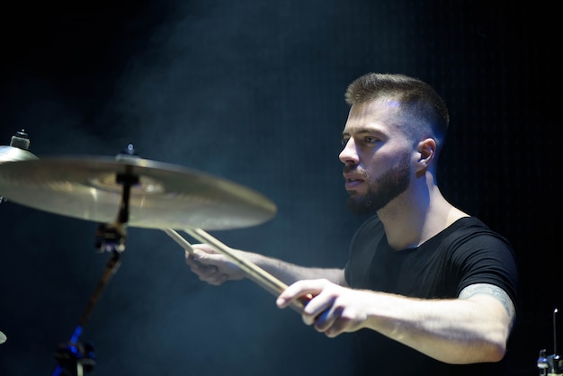 Foto baterista tocando bateria no palco
