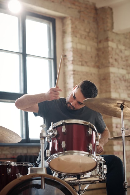 El baterista tocando la batería sentado en el kit de batería