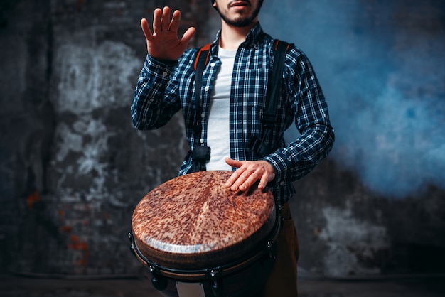 Baterista tocando tambor de madeira, músico em movimento