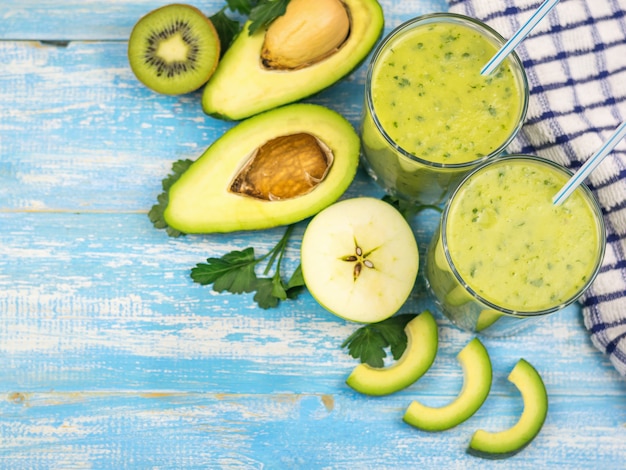 Foto batido de aguacate con frutas cortadas de kiwi, aguacate y hierbas alimentos crudos