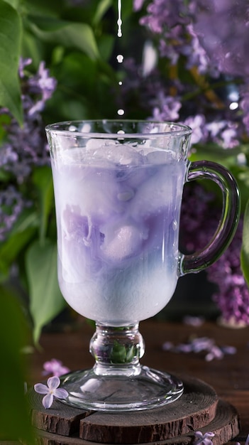 Foto batido de anchang batido azul entre flores lilas