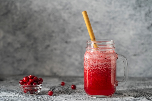 Batido de arándanos y arándanos en tarro de albañil con paja de bambú Refrescante bebida de frutas de verano El concepto de alimentación saludable Copiar espacio