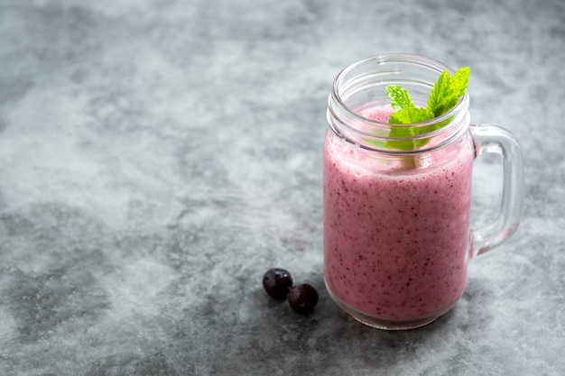 Batido de bayas de fruta fresca en frasco de vidrio con hojas de menta, gris Detox, bebida de verano