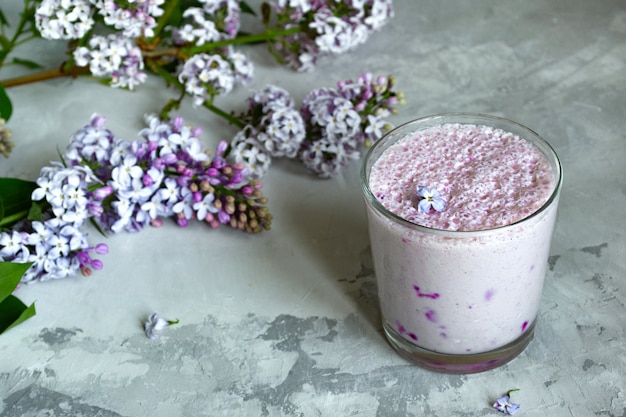 Batido de bayas en un vaso sobre gris