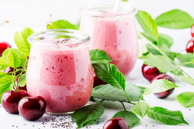 Batido de cereza rosa o batidos con bayas frescas y semillas de chia lugar de fondo de cocina de piedra blanca para la vista superior del texto