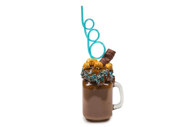 Batido de chocolate con crema batida, galletas, gofres, servido en tarro de cristal. Batido dulce "Freak or crazy". Aislado. Espacio para texto o diseño.