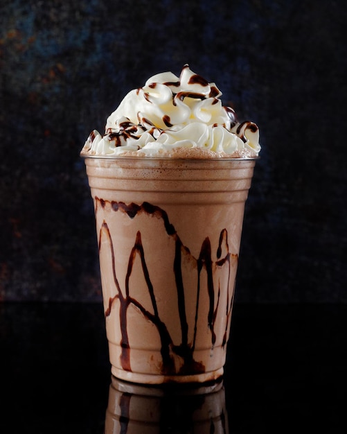 Foto batido de chocolate servido en un vaso transparente sobre un fondo oscuro bebida aislada