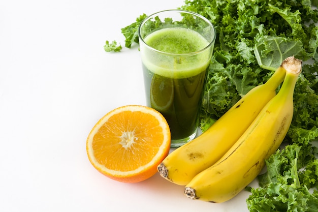 Batido con col rizada, plátano y naranja aislado en el espacio de la copia en blanco