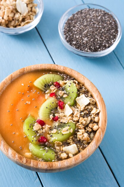 Batido com cereais de frutas e chia na mesa de madeira azul