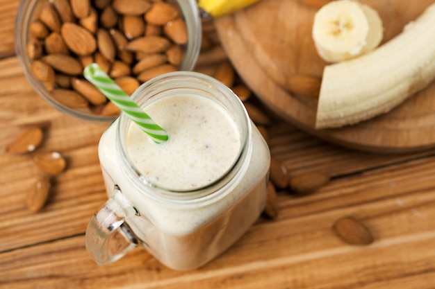 Batido de banana fresca em uma mesa de madeira em uma jarra