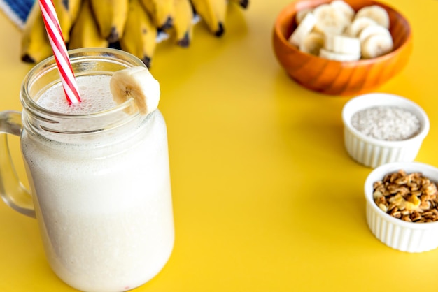 Batido de banana shake saudável com bananas ao fundo