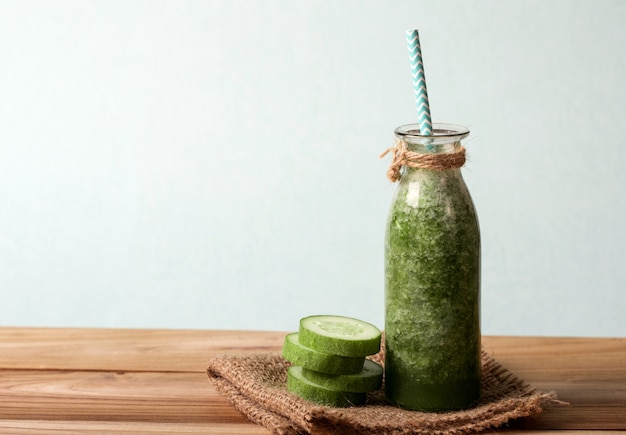 Batido de pepino verde desintoxicação em uma mesa de madeira, bebida vegetal para a saúde