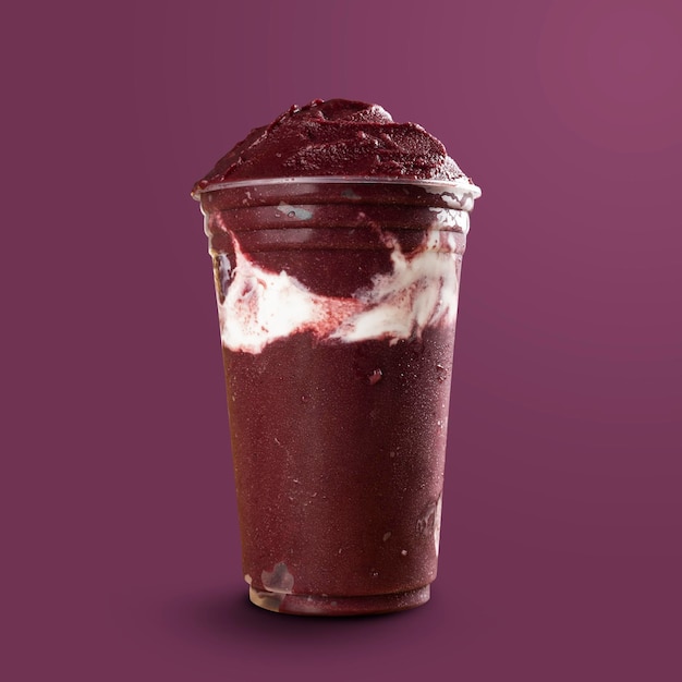 Batido de Sorvete de Açaí Congelado Brasileiro em copo plástico com Leite Condensado. isolado no fundo roxo. Vista frontal para menu e mídias sociais